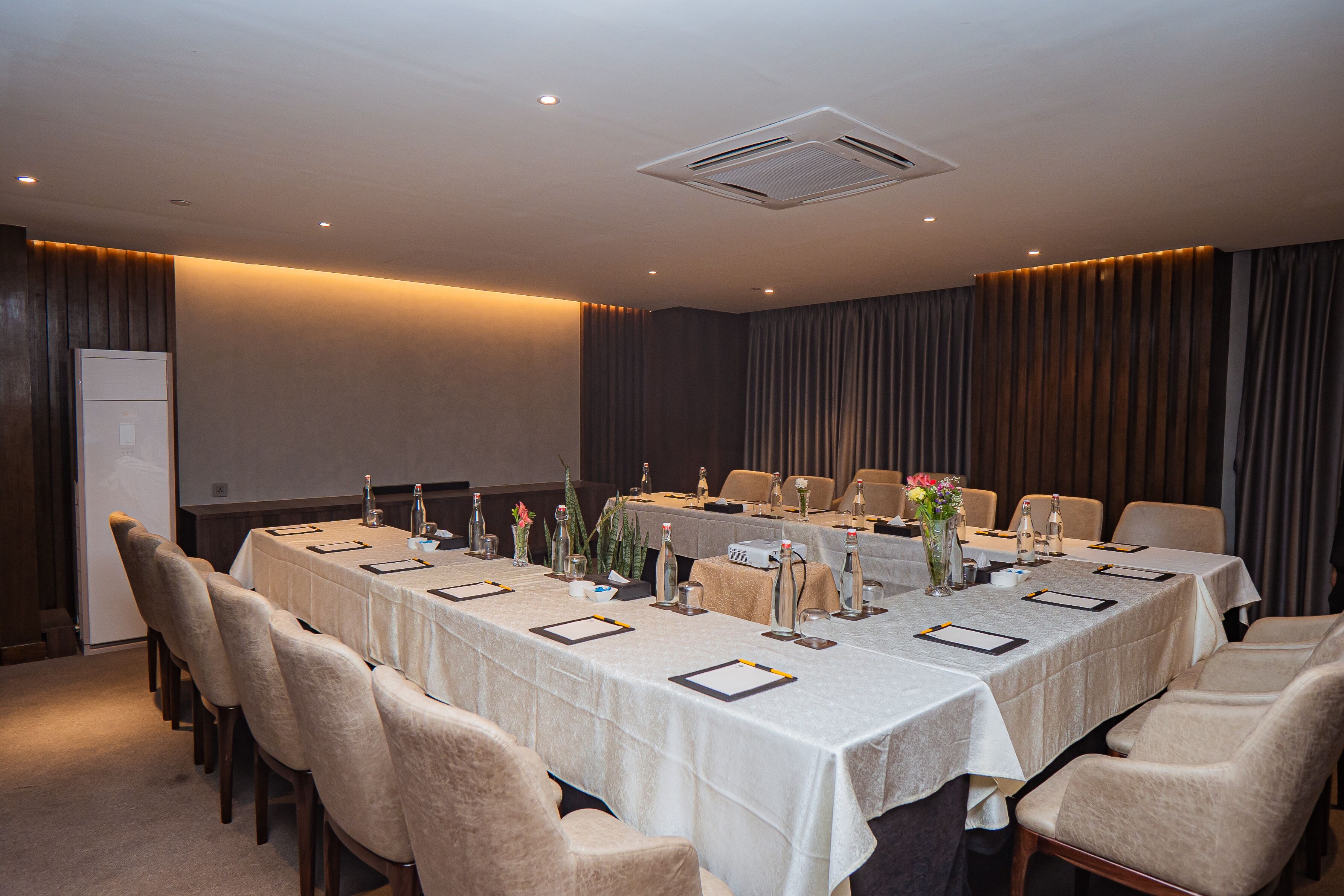A conference room with a long table, chairs, and a projector.