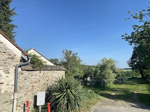 A rustic stone building with a sloped roof and a visible gutter system.