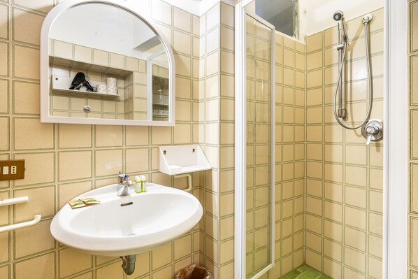 Un baño con lavabo, espejo y ducha.