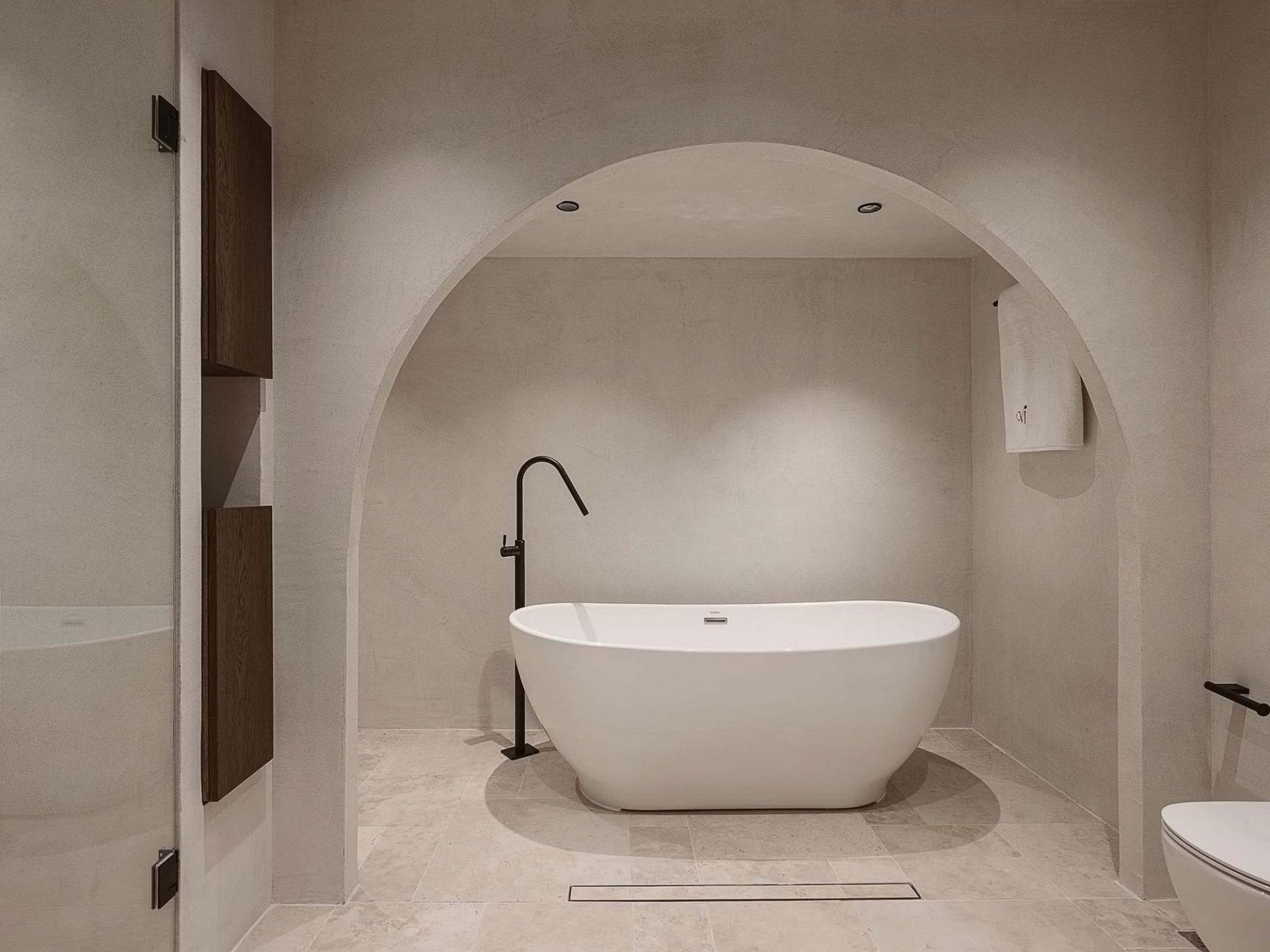 Ein modernes Badezimmer mit einer freistehenden Badewanne, einer Wandtoilette und einem Handtuchhalter.
