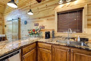 Fully equipped kitchen with dishwasher, coffee maker, and sink.