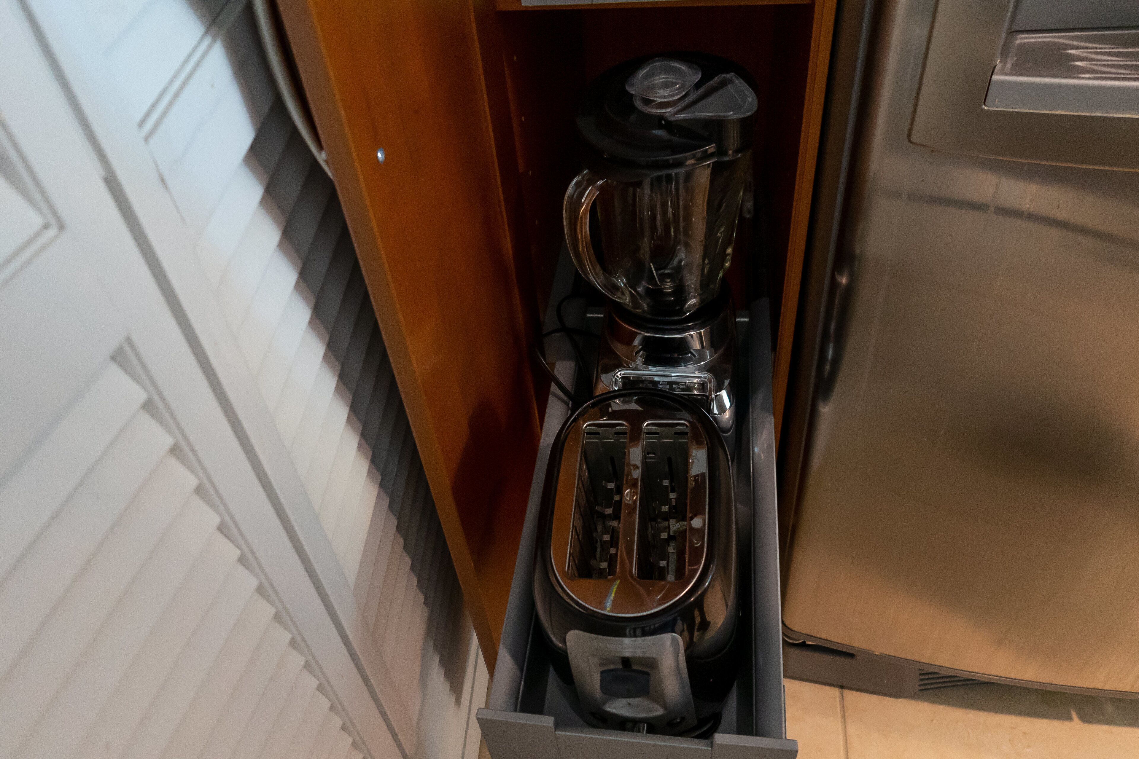 A kitchen with a built-in toaster and a blender drawer.