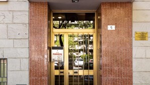 A building entrance with a tiled facade, a numbered plaque, and a sign indicating public access. - Appartamento Ibisco by Wonderful Italy (Bologna)