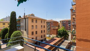 A residential building with multiple balconies, a clear sky, and a view of neighboring buildings. - Appartamento Ibisco by Wonderful Italy (Bologna)