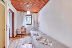 A small, cozy room with a wooden ceiling, a single bed, a chair, a small table, and a window with curtains. - Lovely House Near Zagreb With Terrace (Ivanic-Grad)
