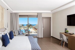 Une chambre d’hôtel équipée d’un lit, d’un bureau, d’une chaise, d’une télévision et offrant une vue sur une piscine et un paysage.