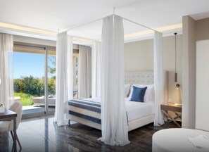 A modern bedroom with a four-poster bed, a view of the outdoors, and a dining area with a table and chairs. - Ajul Luxury Hotel & Spa Resort Registry Collection (Kassandra)
