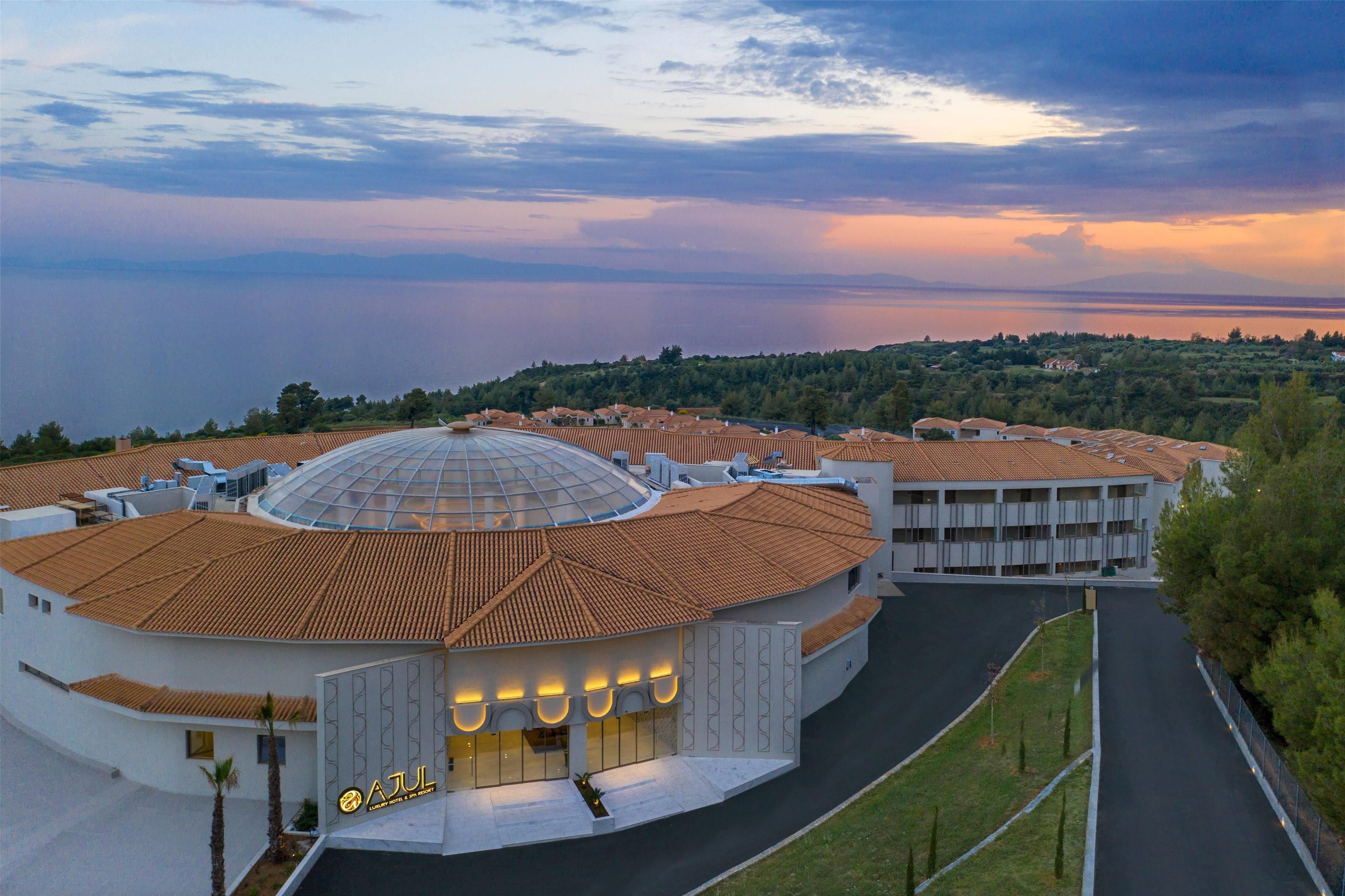 Un edifici amb cúpula i estructura circular, envoltat d'una zona d'aparcament i vegetació.