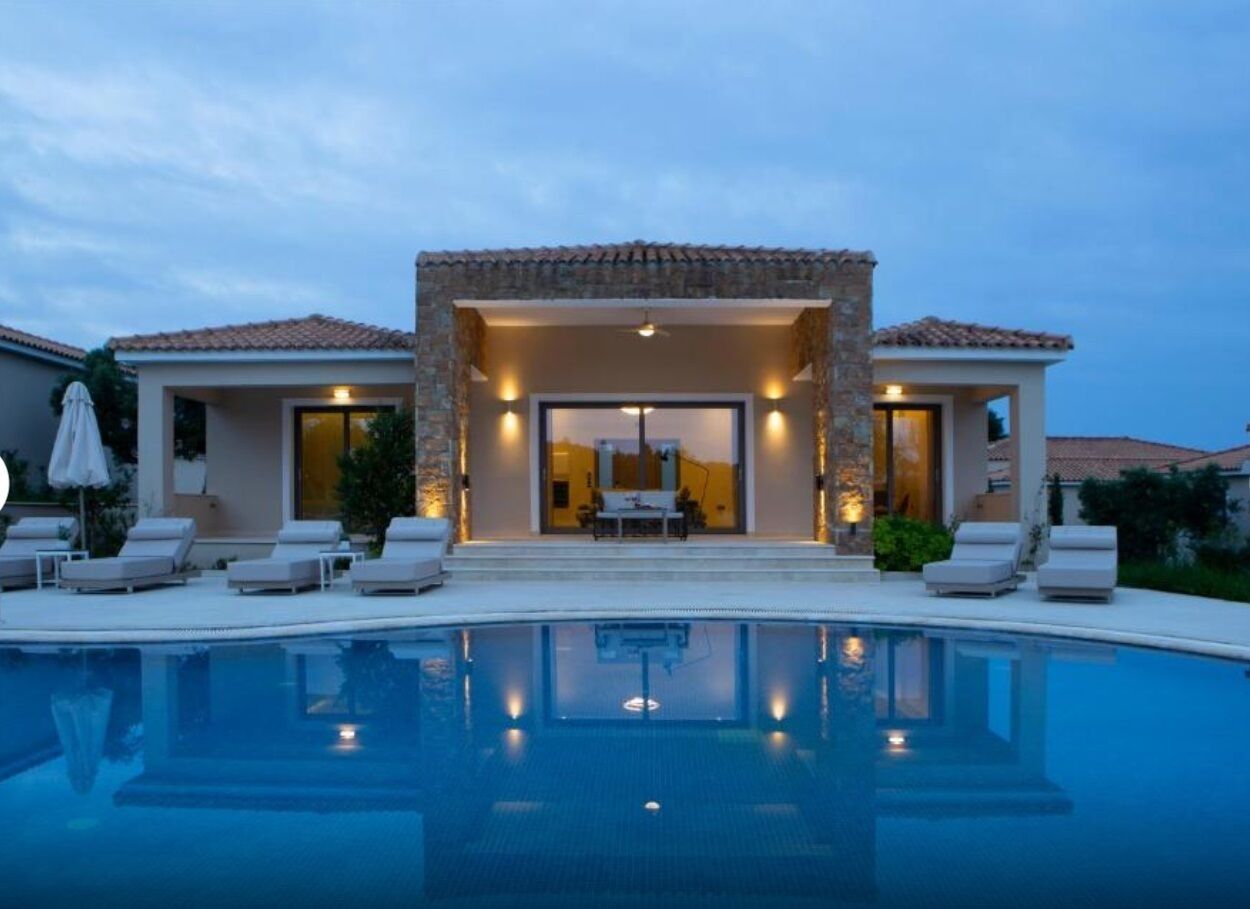 A modern house with a swimming pool, outdoor seating, and a patio area.
