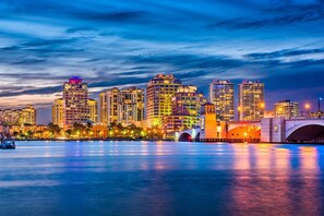 A city skyline with high-rise buildings, a bridge, and a calm waterfront.