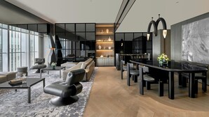 A modern interior with a sofa, dining table, and chairs, a fireplace, and a large window. - Kimpton Qiantan Shanghai by IHG (Shanghai)