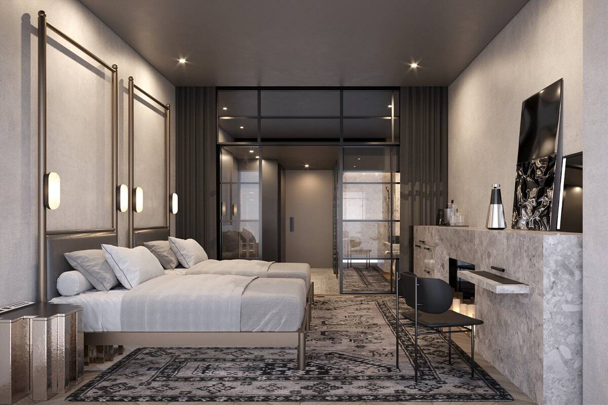 A modern bedroom with a large bed, a seating area with a sofa and chairs, a fireplace, and a television mounted on the wall.
