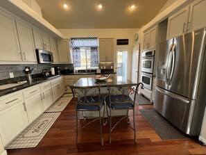 Enjoy cooking in this well-lit kitchen with a central island and chairs.