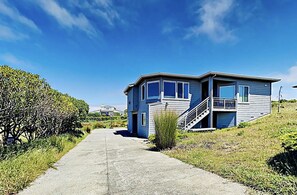 Situated on a grassy hill, this house offers a balcony with a view.