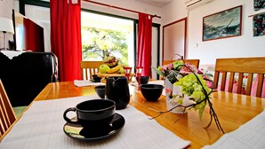 A dining table with a black cup and saucer, a pitcher, bowls, and a vase with flowers. - Apartments Sunset - Two Bedroom Apartment with Terrace and Sea View (Blato)