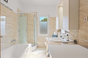Bathtub, hair dryer, towels, toilet paper