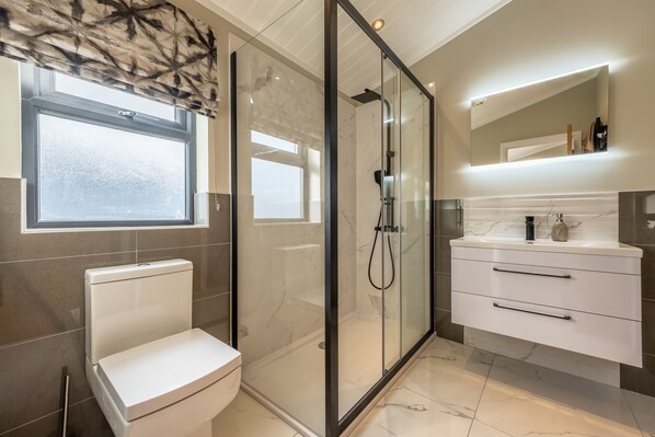 A modern bathroom with a glass-enclosed shower, a toilet, and a vanity with drawers. - Twelve Burnham Lodge (6), Burnham Market, Norfolk (Burnham Market)