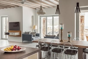 Relax in this stylish living space with a central dining table, flat-screen TV, and comfortable sofa.