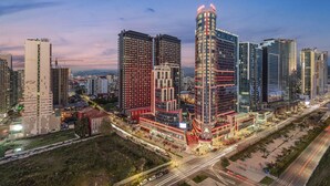 Een hoog hotel met meerdere verdiepingen, een opvallende, gebogen constructie en een goed verlichte gevel.
