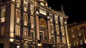 Un bâtiment historique à l’architecture riche et élaborée, doté de grandes fenêtres et d’un dôme imposant.