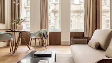 Un salon moderne comprenant un canapé, une table basse et un coin repas avec des chaises et une table.