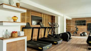 A modern gym with treadmills, a rowing machine, and a stationary bike.