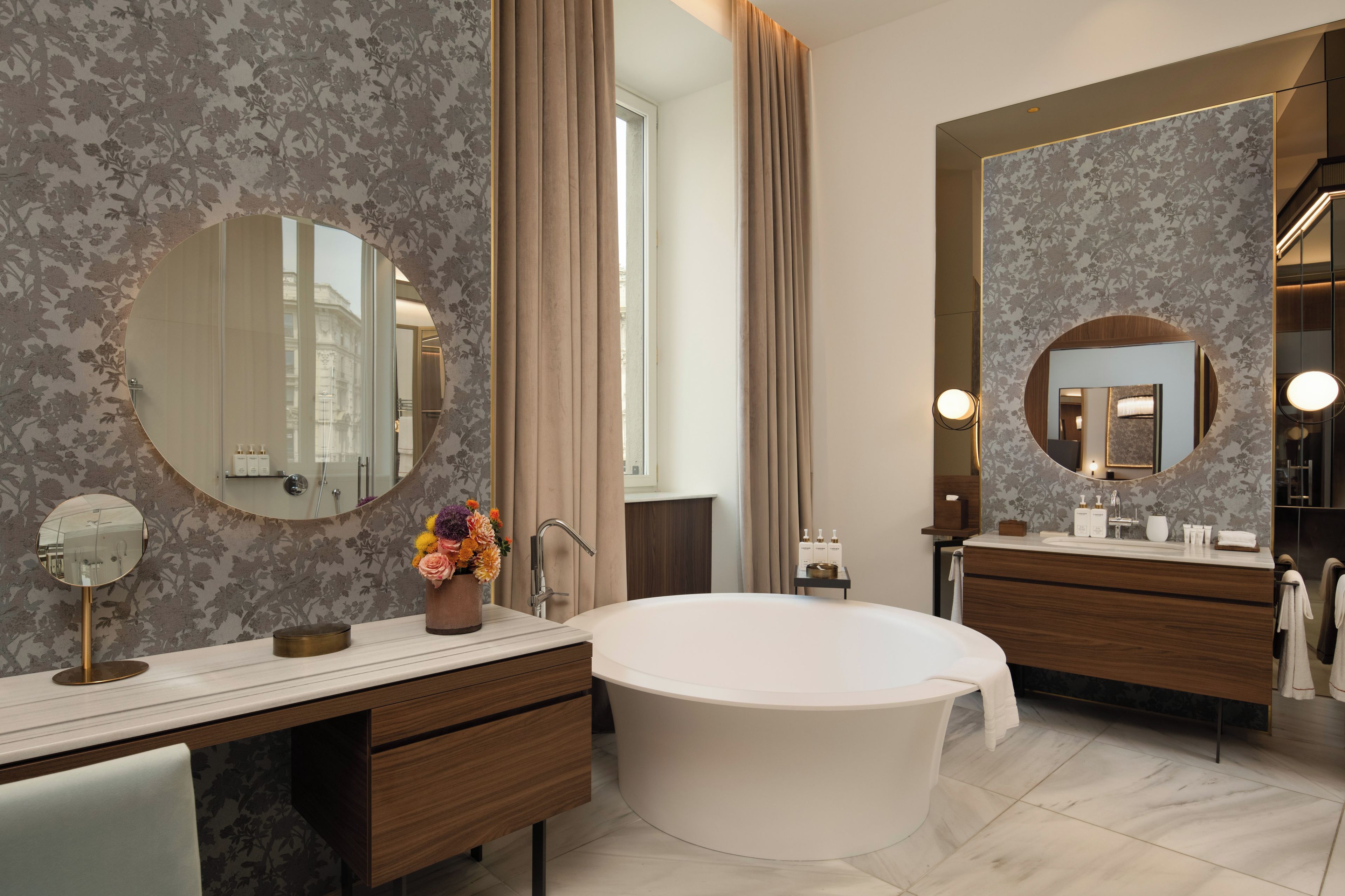 Une salle de bain moderne avec une baignoire sur pieds, un meuble-lavabo avec un miroir et un grand miroir au-dessus du lavabo.