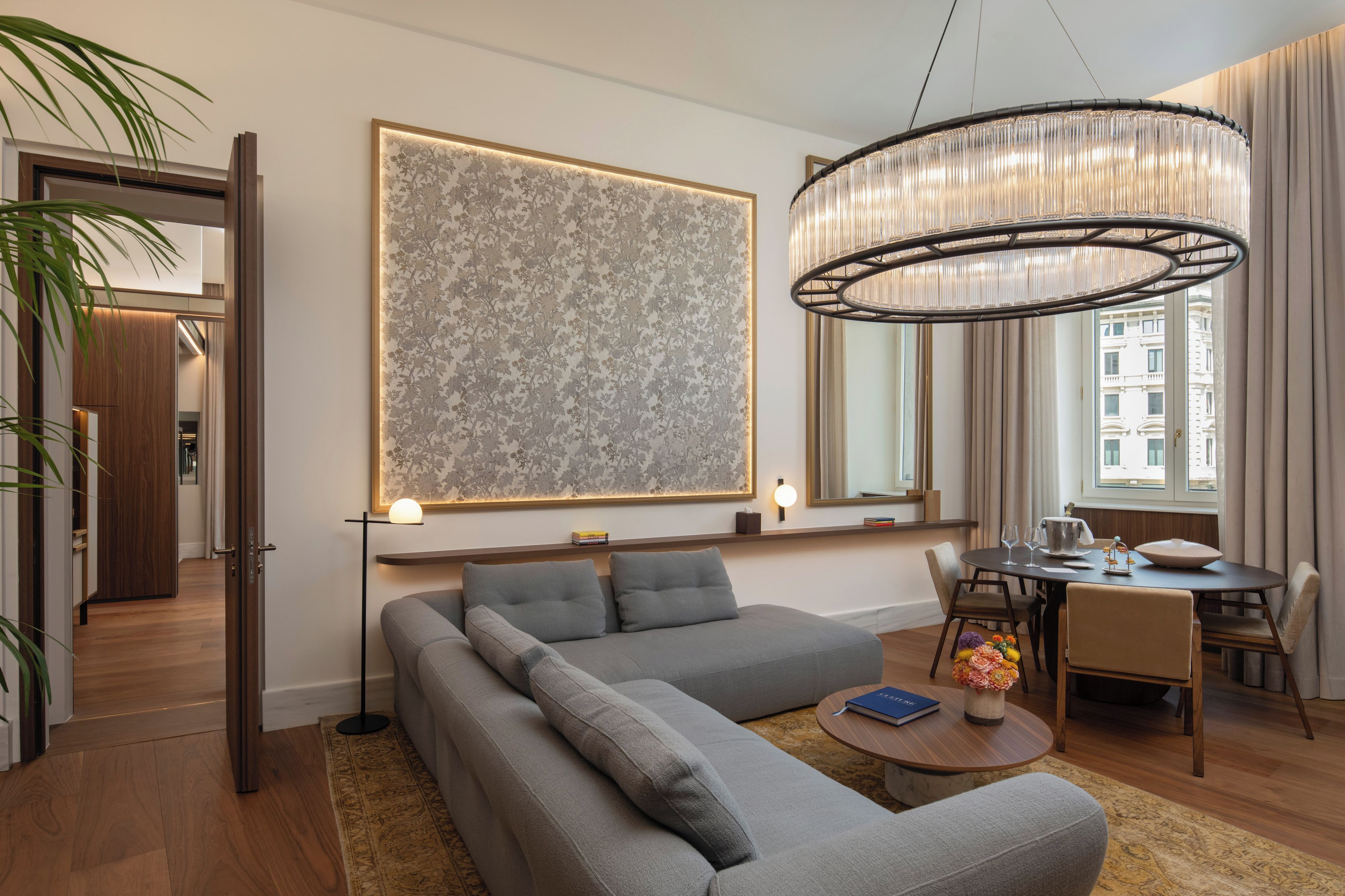 Una sala de estar moderna con un sofá modular, una mesa de comedor y un cuadro abstracto grande.