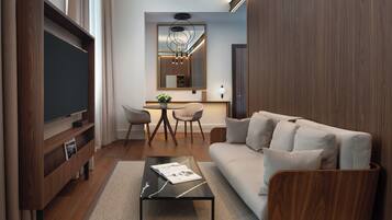 A modern living room with a flat-screen TV, a sofa, a coffee table, and a dining area with chairs and a table.