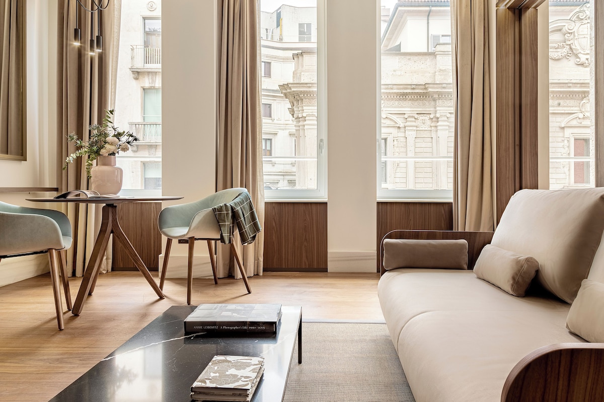 Una sala de estar moderna con un sofá, una mesa de centro y una zona de comedor con sillas y una mesa.