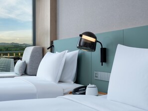 A hotel room with a bed, a nightstand, a lamp, and a view of a bridge and mountains. - Even Shenzhen Guangming Cloud Park (Shenzhen)