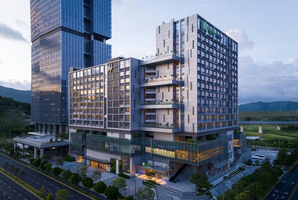 A modern hotel with a glass facade, multiple balconies, and a rooftop terrace. - Even Shenzhen Guangming Cloud Park (Shenzhen)