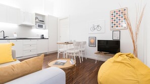 Un ambiente moderno e minimalista con angolo cottura, zona pranzo e area salotto.