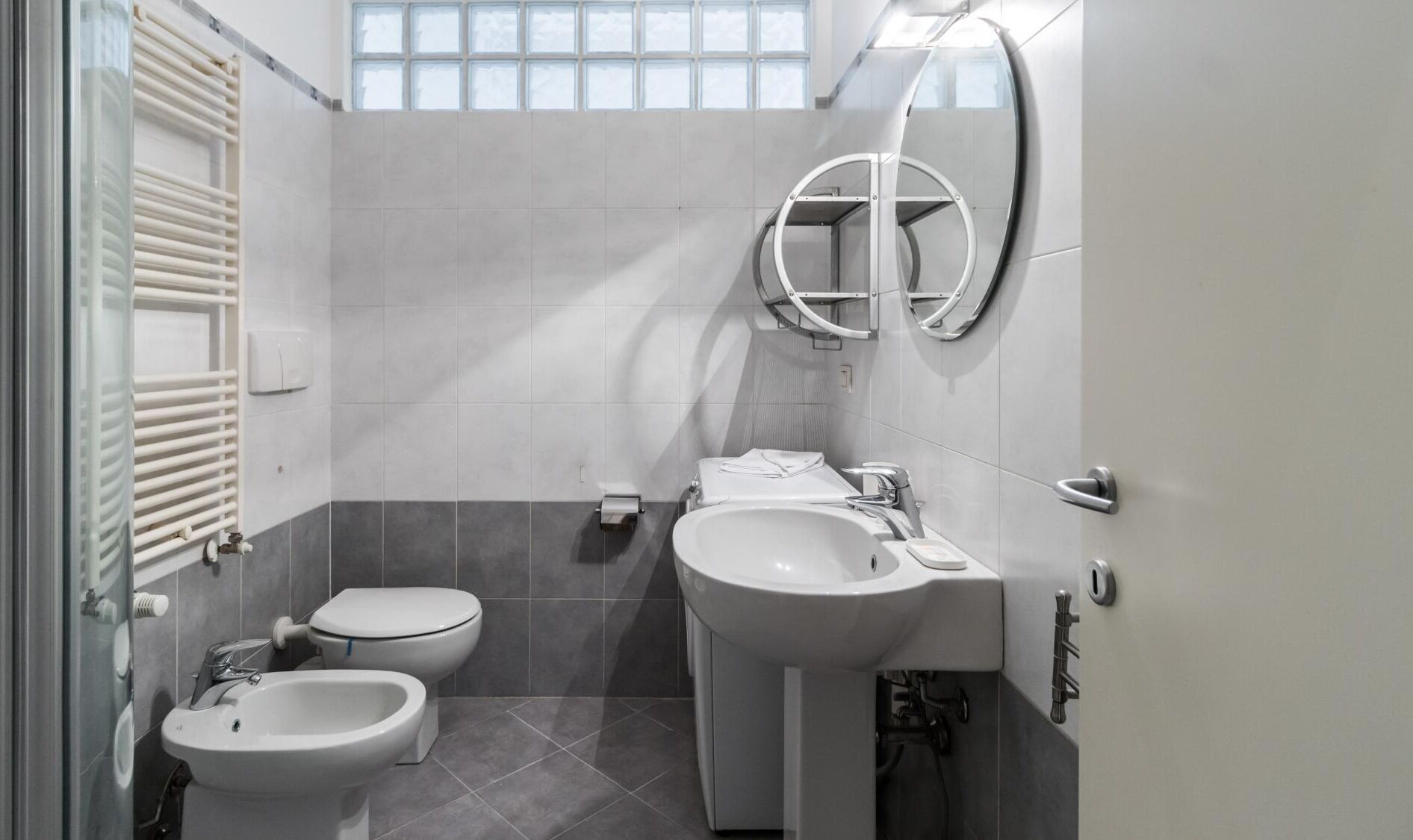 Ein modernes Badezimmer mit Toilette, Bidet und Waschbecken.