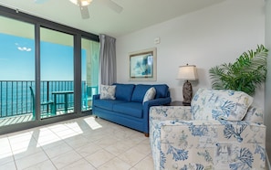 Relax in a coastal-inspired living area with a sofa, framed artwork, and a potted plant.