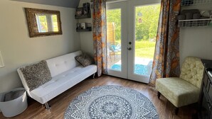 Un salon chaleureux avec un canapé blanc, un tapis à motifs et un fauteuil.