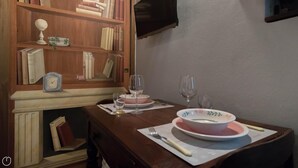 A dining table set with plates, glasses, and a clock. - Italianway Easy - San Calocero 29 (Milan)