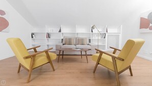 A modern living room with a sofa, two yellow armchairs, a coffee table, and white shelving units. - Italianway Easy - Ripa Ticinese 17 B (Milan)