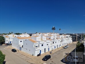 Residential area with flat-roofed buildings arranged in a grid pattern, offering parking spaces and a well-maintained environment.