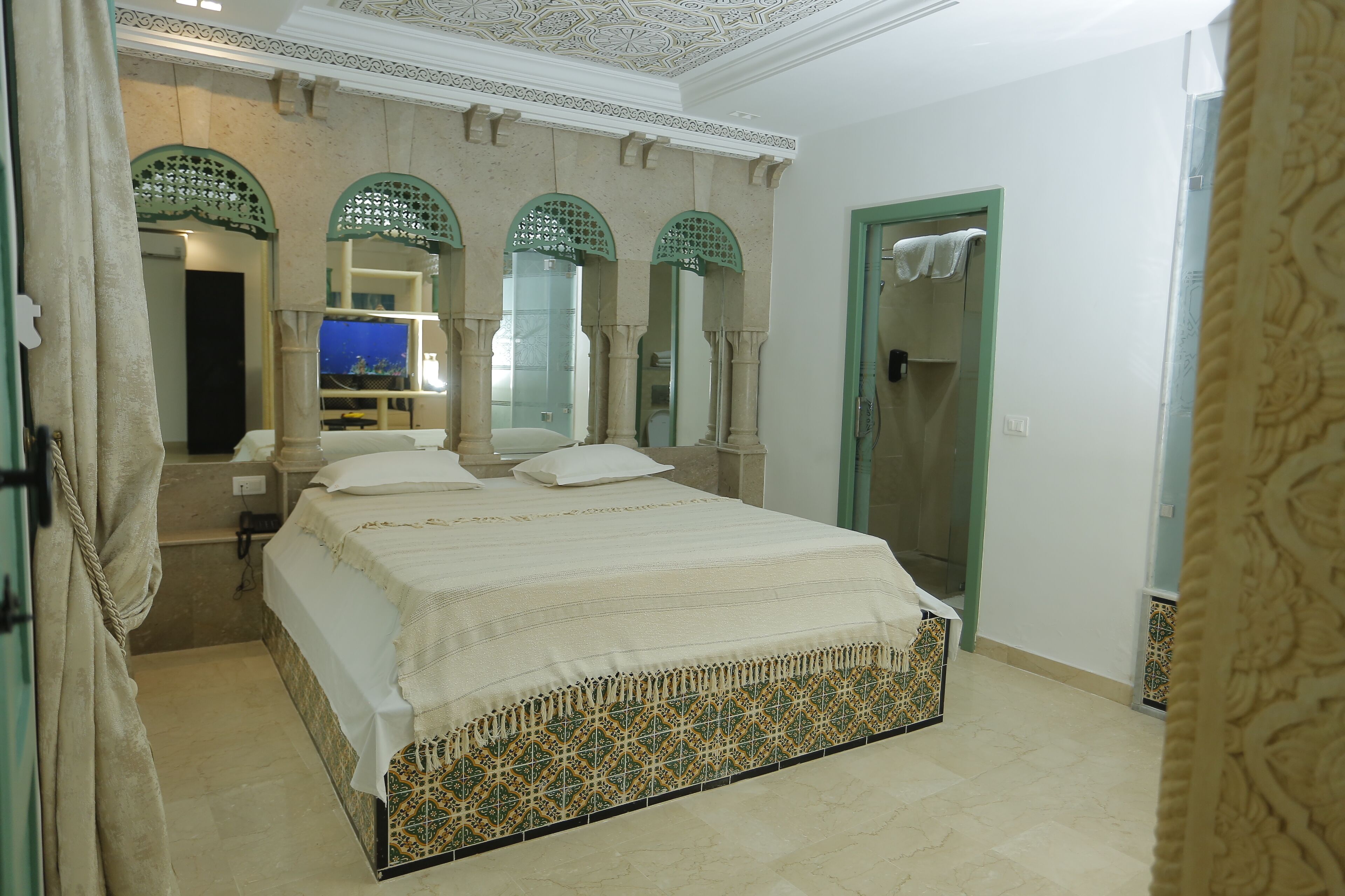 Un dormitorio con una cama grande, un espejo y una puerta.