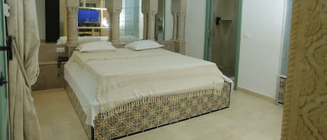 Un dormitorio con una cama grande, un espejo y una puerta.