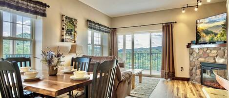 A spacious living area with a fireplace, dining table, and comfortable seating.