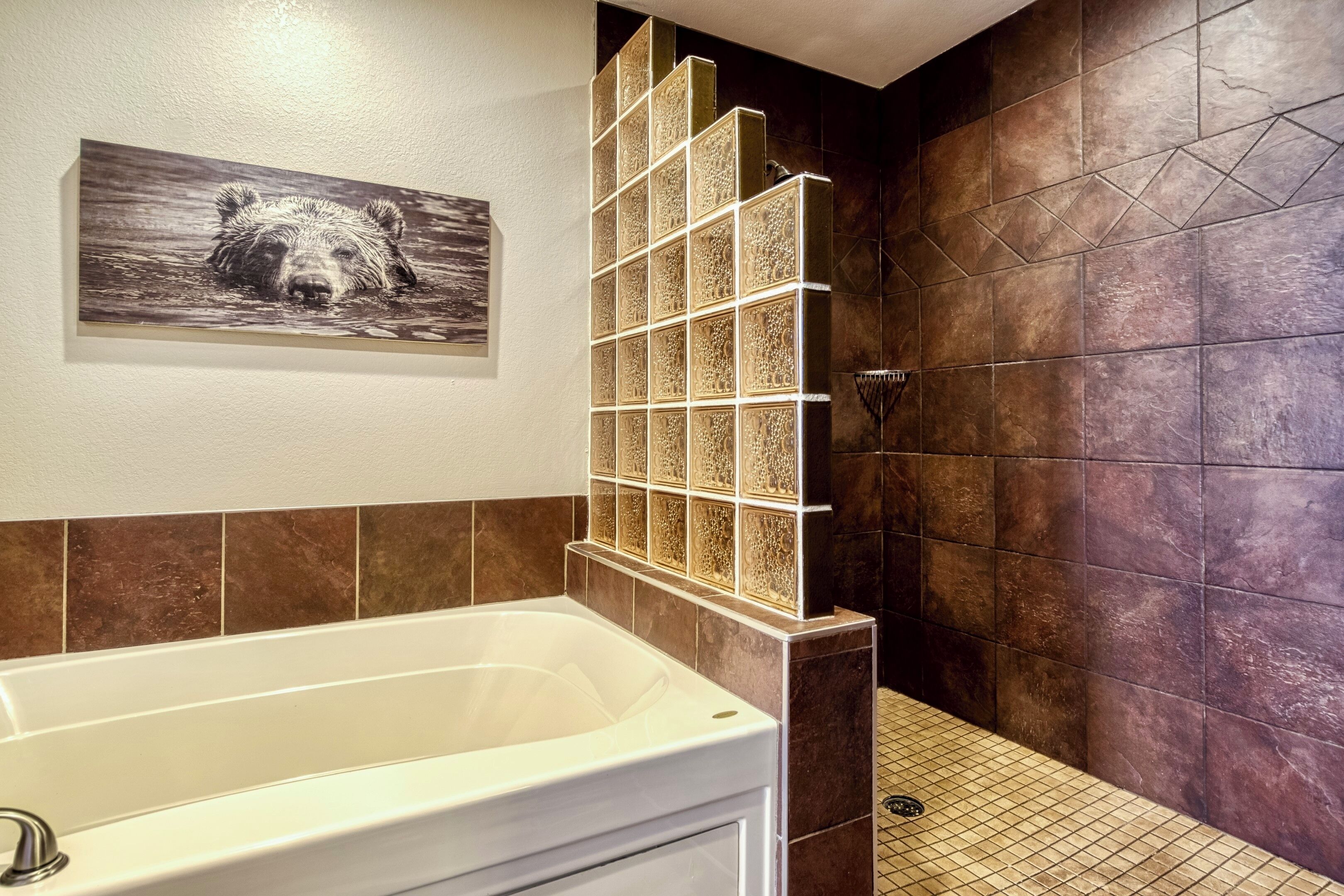 A bathroom with a bathtub, a shower, and a tiled wall.