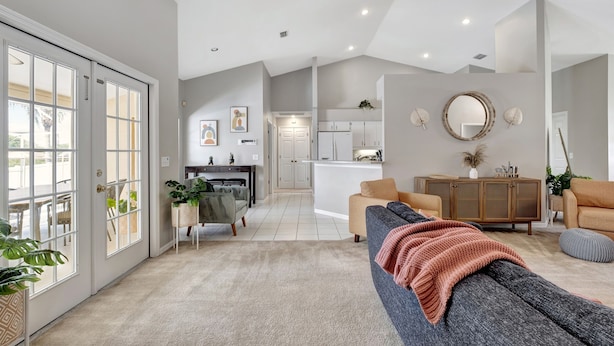 A modern living room with a grey sofa, a wooden cabinet, and a dining area with a table and chairs. - Pool | Waterfront Lake | 12 PPL | Gorgeous (Riverview)