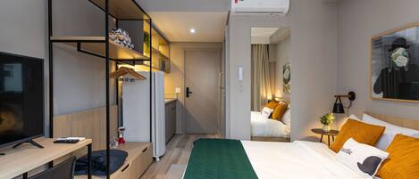 Una habitación de hotel moderna con cama, escritorio y armario.