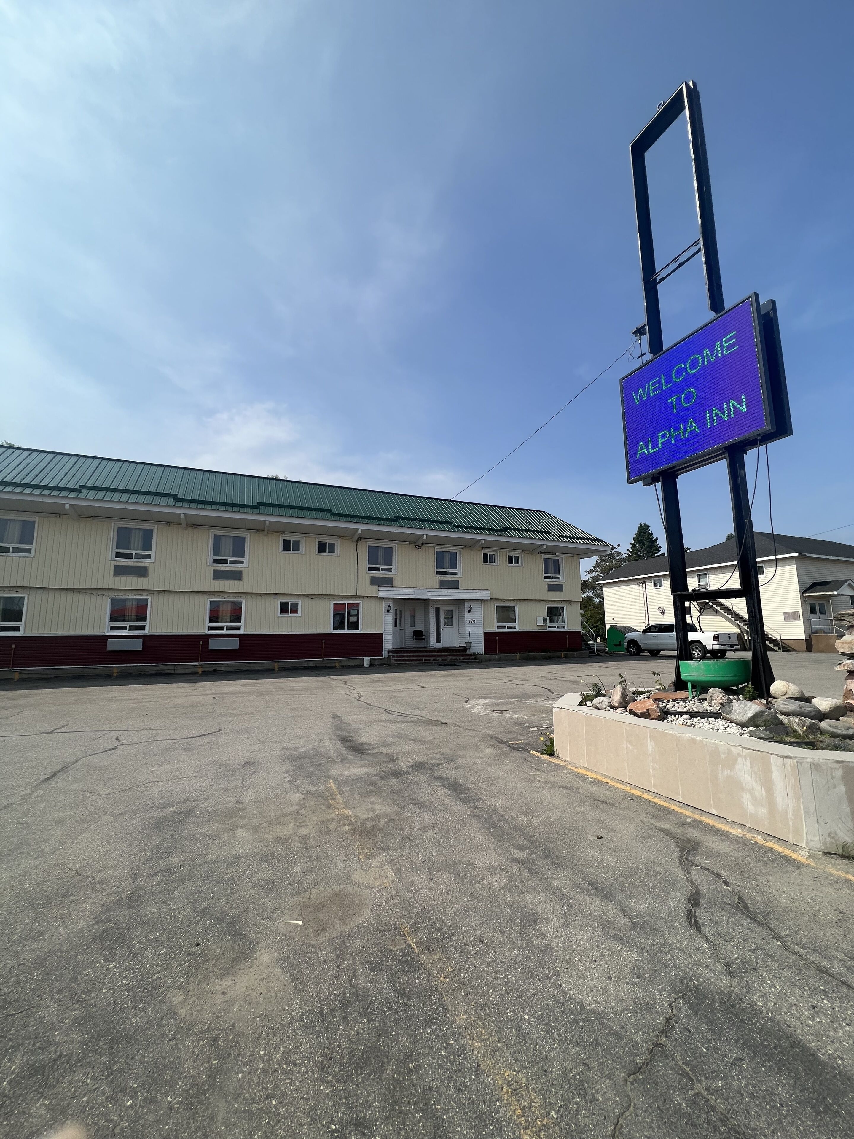 En bygning med et skilt, der siger "WELCOME TO ALPHA INN".