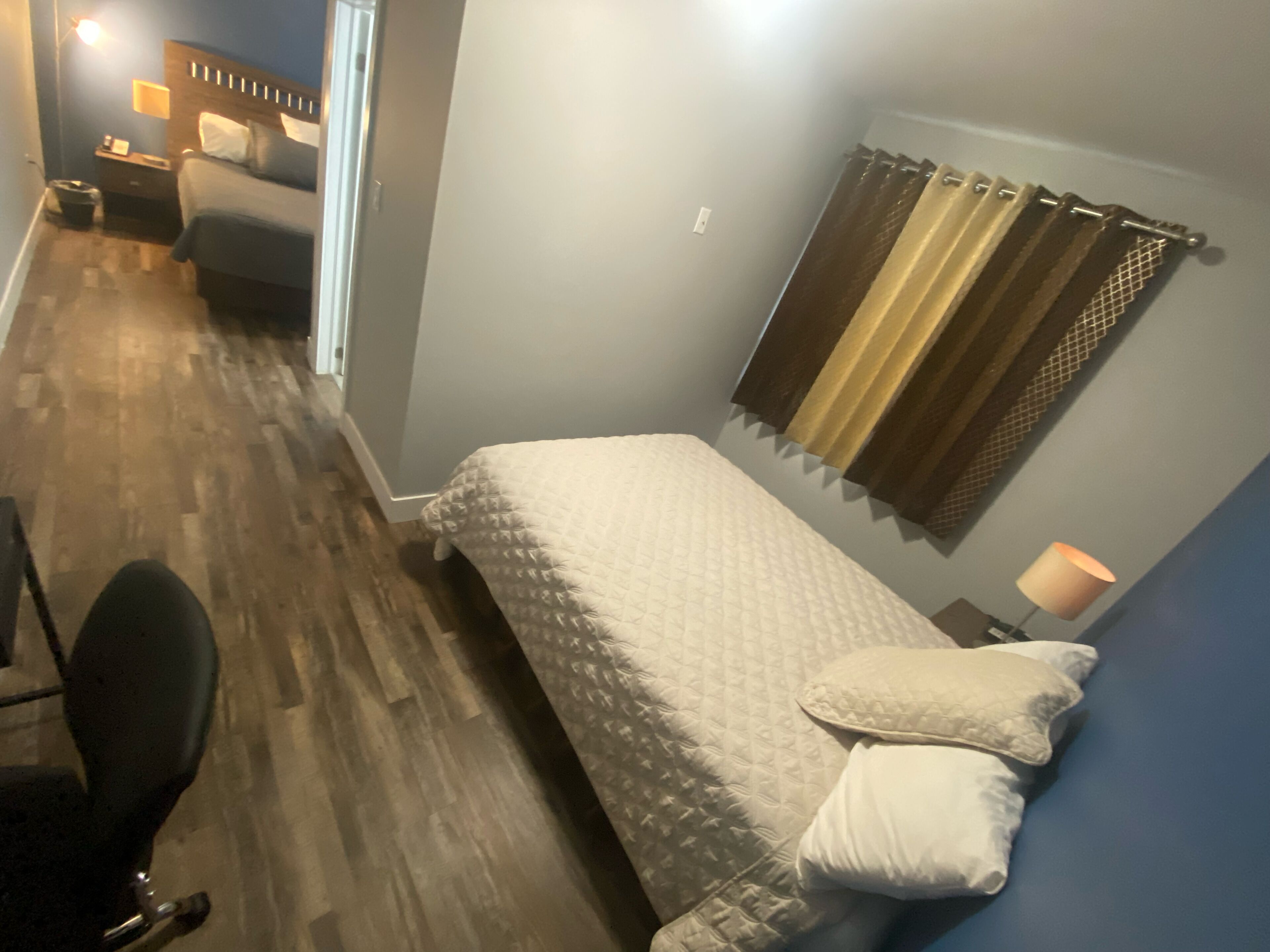 A small, compact bedroom with a single bed, a chair, and a nightstand.