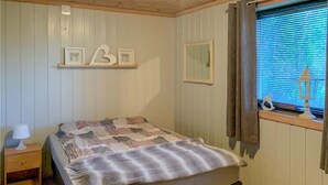 A bedroom with a bed, a nightstand, a mirror, and a window with curtains. - Cozy apartment in Gol with WiFi (Gol)