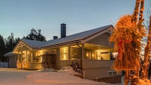 A wooden cabin with a porch, surrounded by snow, and a decorative plant in the foreground. - Cozy apartment in Gol with WiFi (Gol)