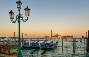 Gondolas docked at a pier with a historic building in the background. - Cozy home in Volpago del Montello with sauna (Volpago del Montello)